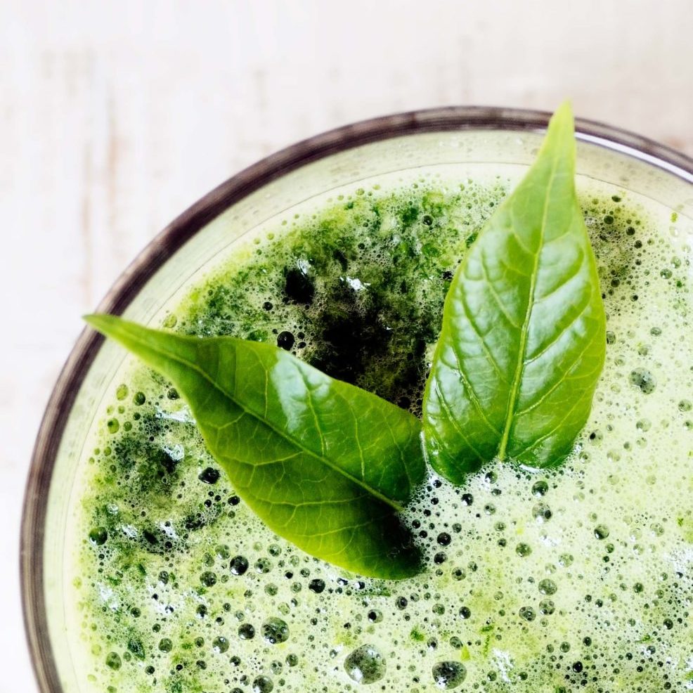 green herbal detox drink made of spinach on white wood